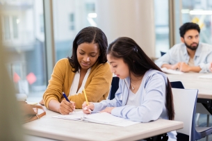 Two students work together at a desk