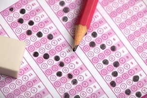 A standardized test answer sheet, with some bubbles filled in, and a pencil and eraser placed on top.