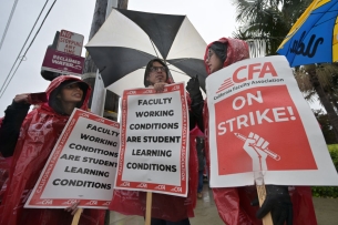 A photograph of strikers, holding umbrellas and signs, including one saying "CFA On Strike!" 