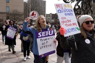 Marching graduate students holding up signs