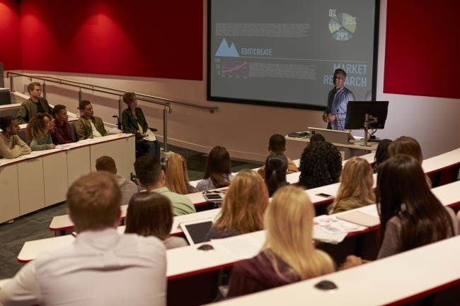 Young adult students at a university lecture, back view