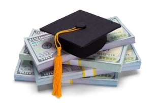 graduation mortar board on top of pile of cash